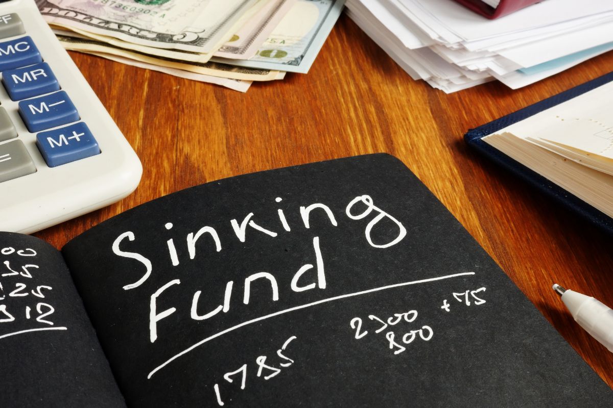 The photo is about dollar bills and a black paper with a sinking fund note.
