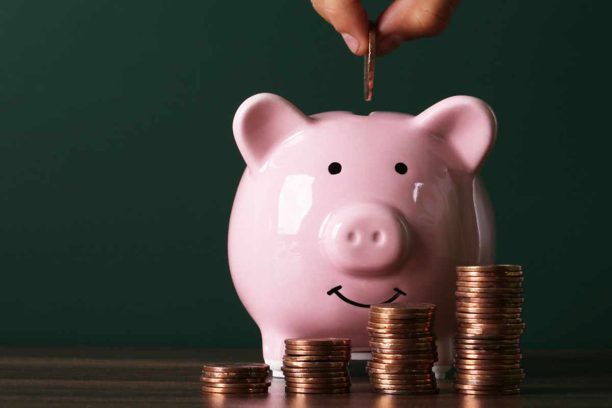 The photo shows coins and a man's hand maximizing his savings.