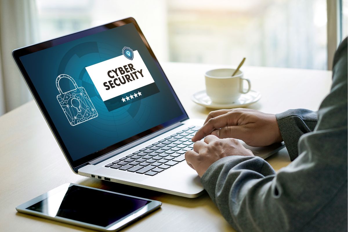 The photo is about a man working as a cybersecurity on a laptop.