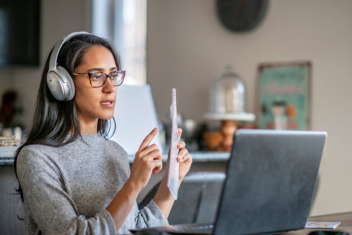 The image shows a woman teaching as an online ESL teacher.