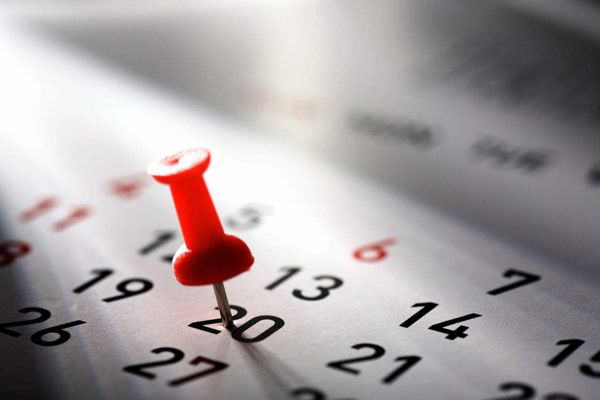 A picture of a pin stuck in a calendar.