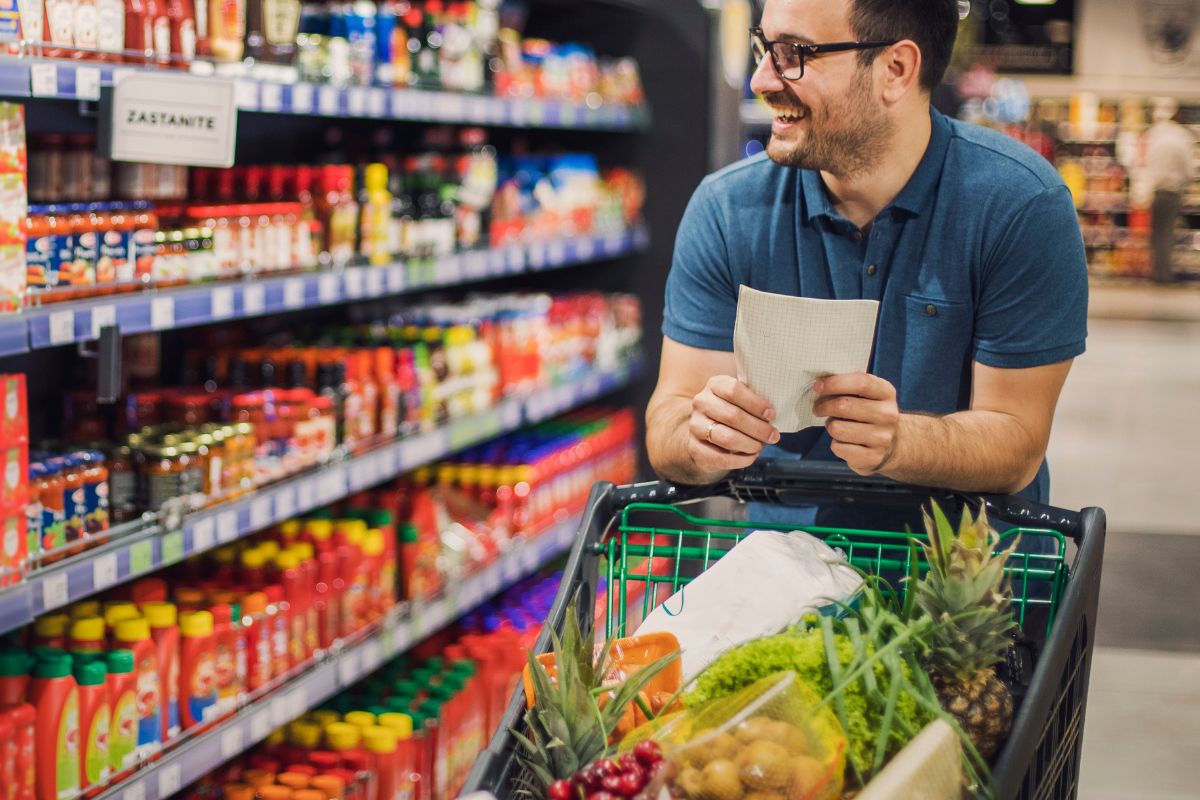 A picture of a man with a pushcart full of healthy foods. 