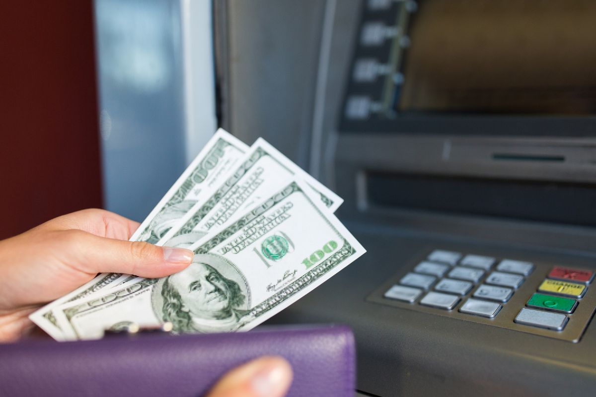 A picture of $300 in front of an ATM machine. 