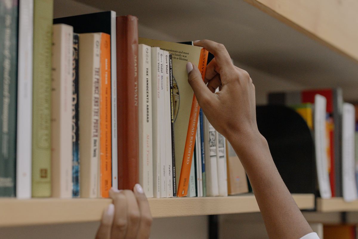 A picture of someone reaching for the books.