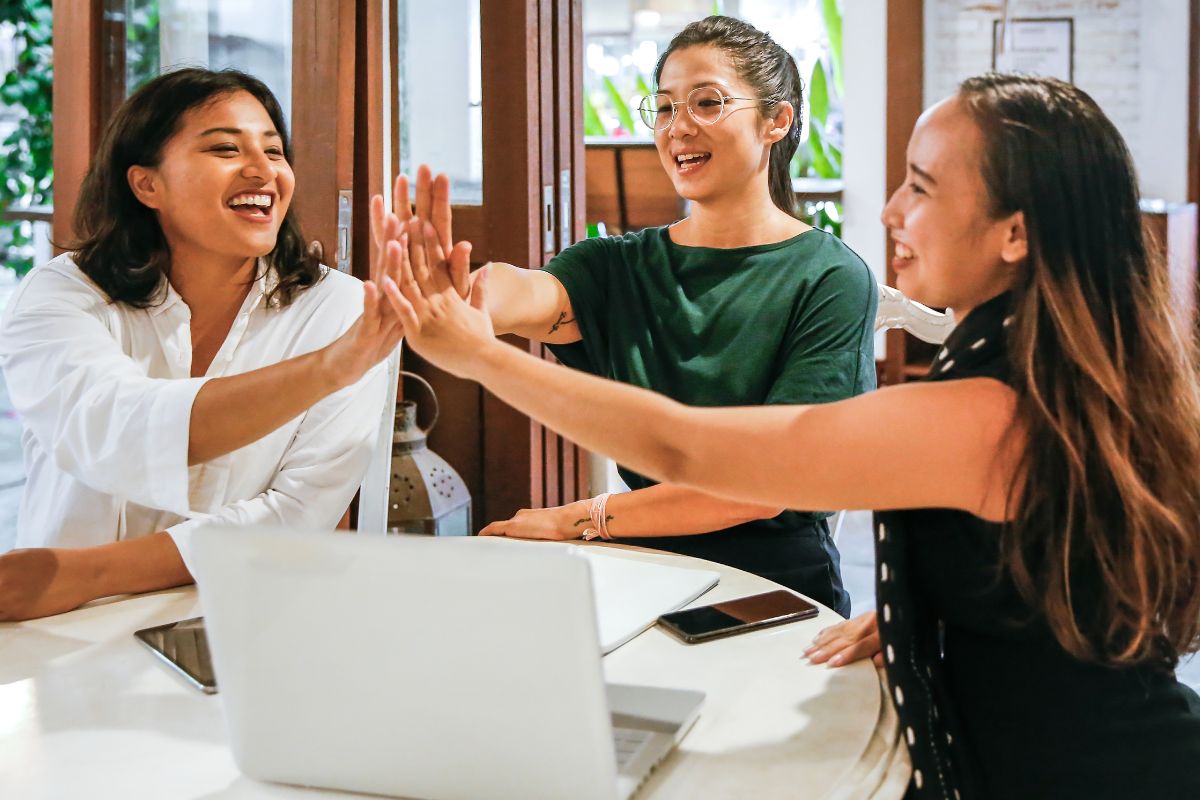A picture of three workmates in a high-five.