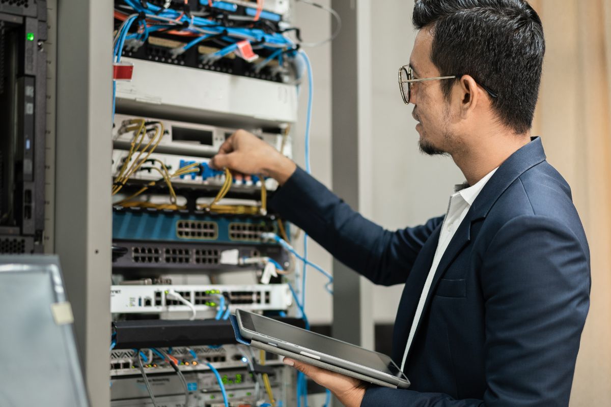 A picture of someone fixing a data center.