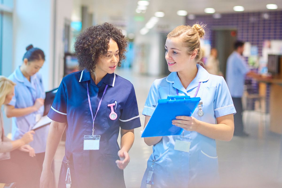 A picture of a nurse talking to a resident. 