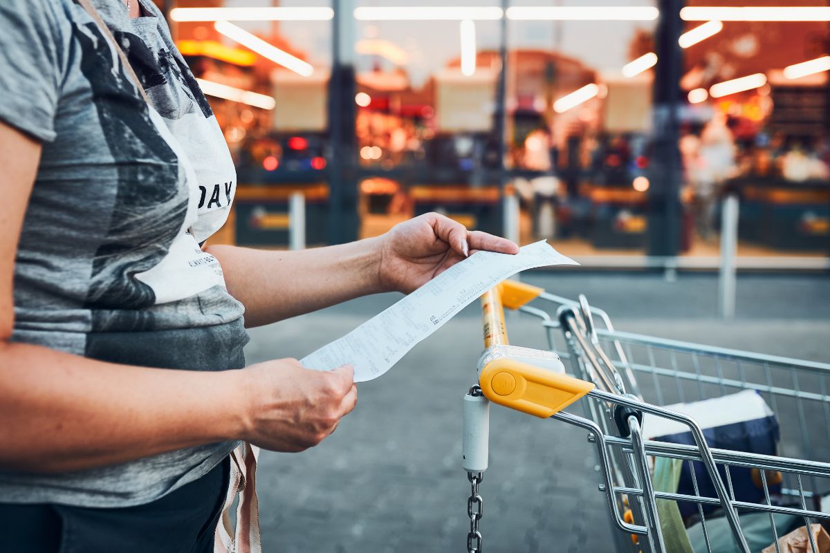 A picture of a lady with a long receipt.