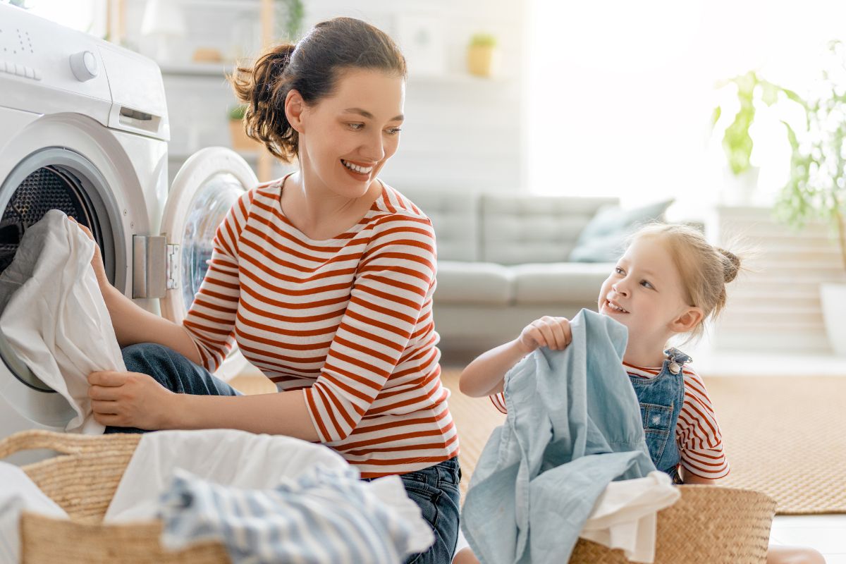 A picture of a mother and her daughter doing laundry.