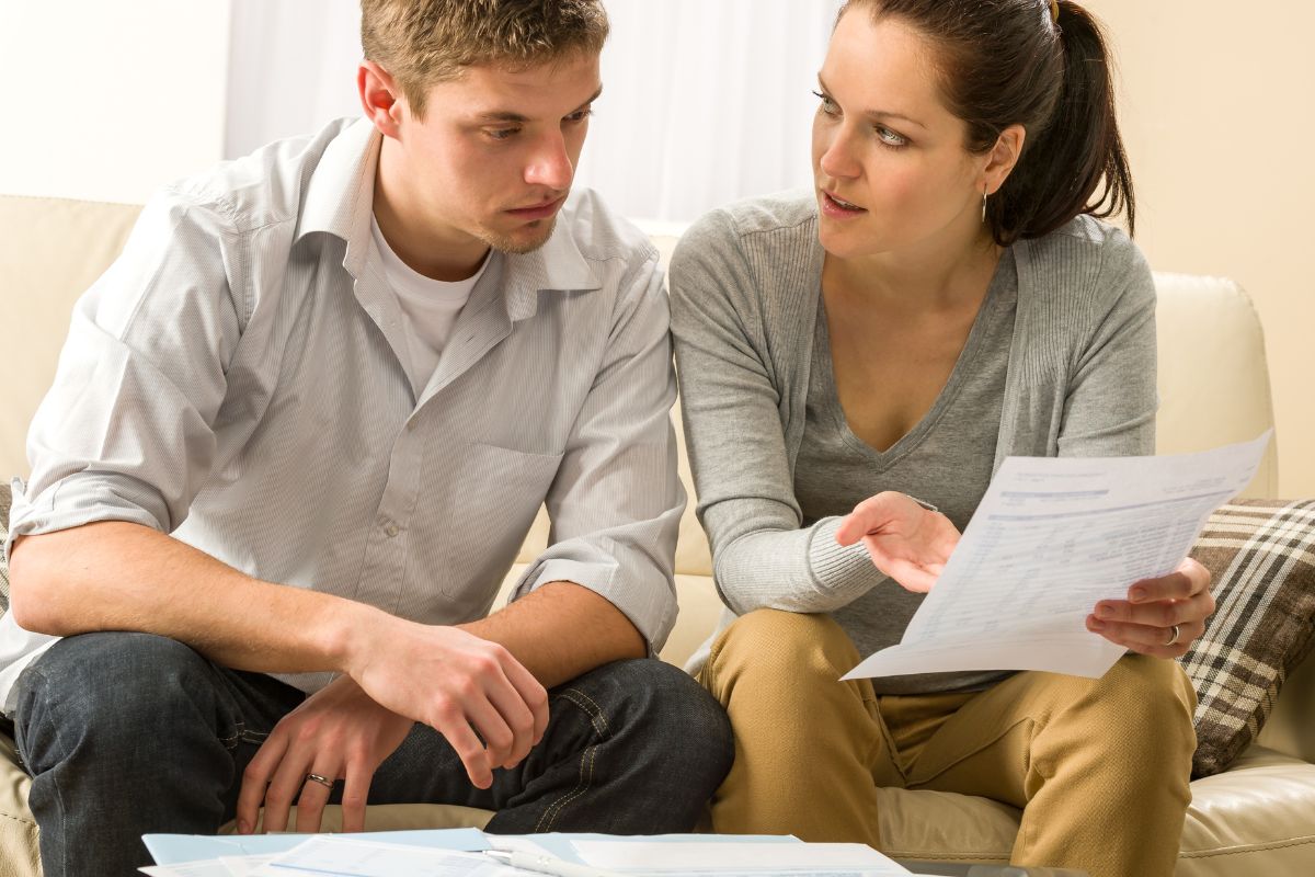 A picture of a couple talking about their expenses.