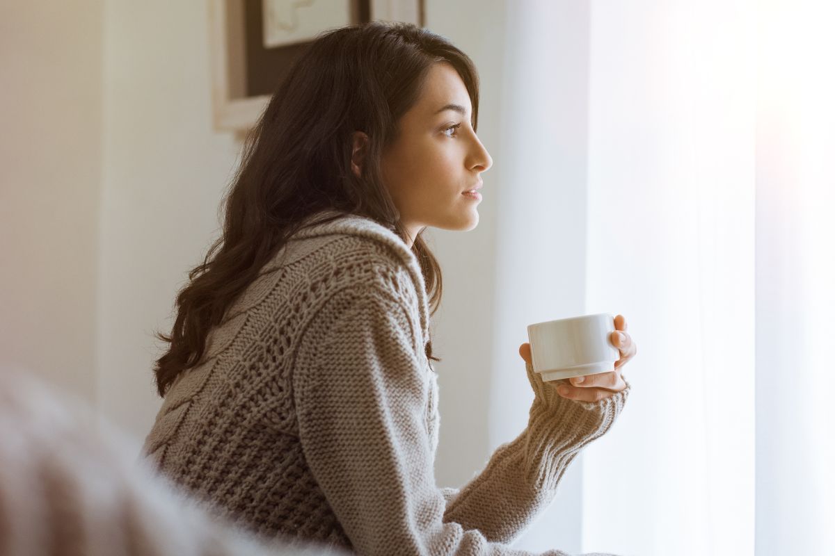 A picture of a lady staring outside. 