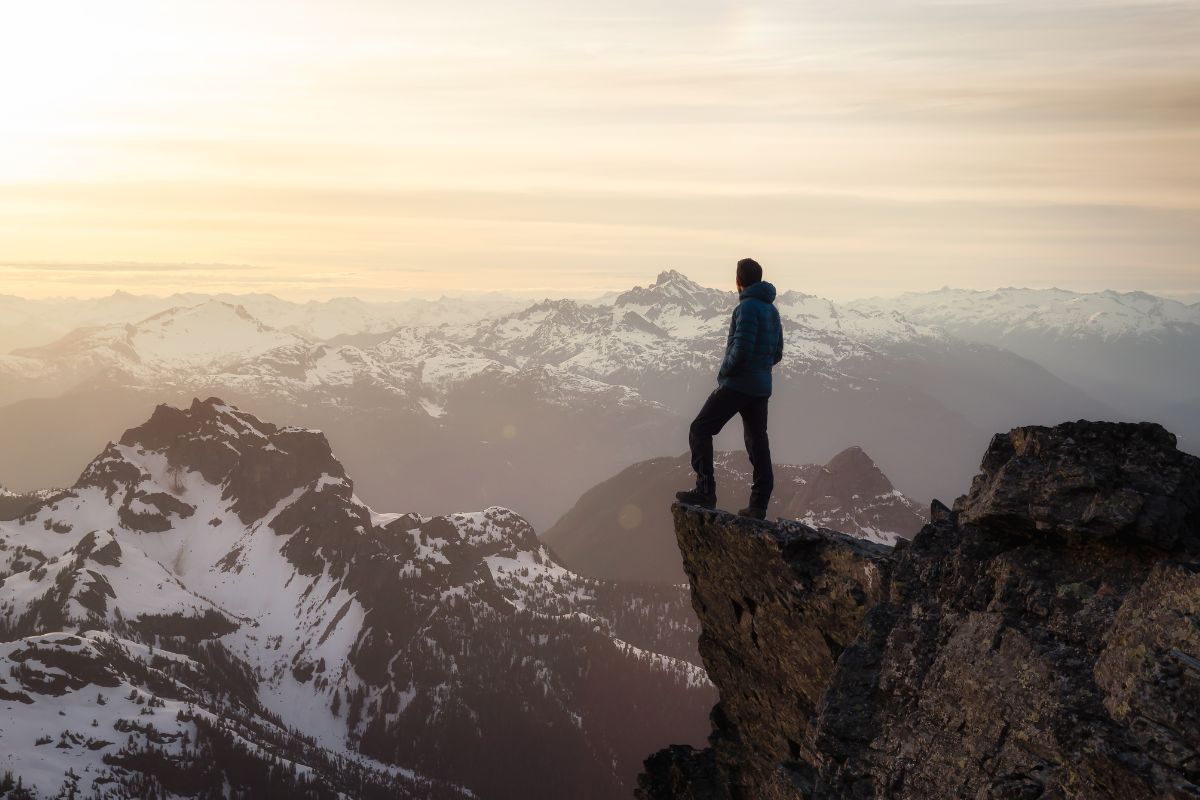 A picture of someone at the summit at a mountain.