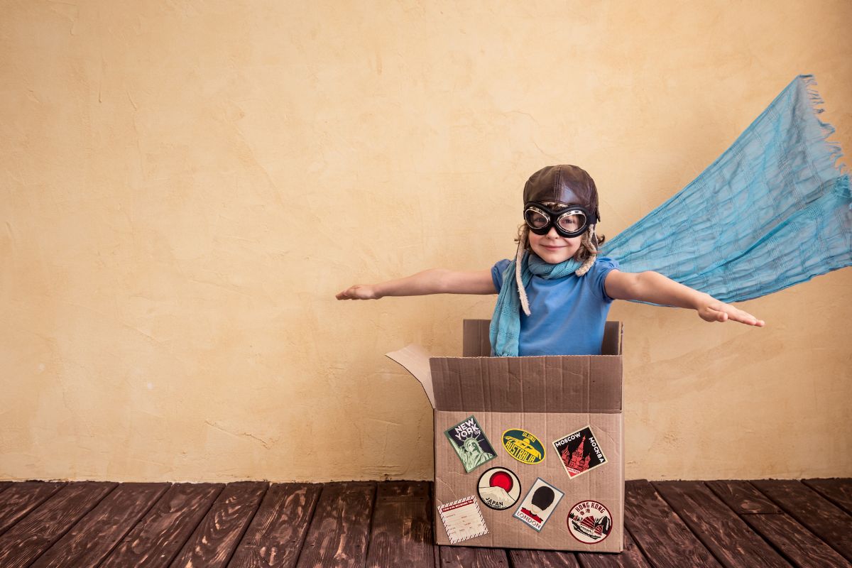 A picture of a child in a box, simulating a pilot.