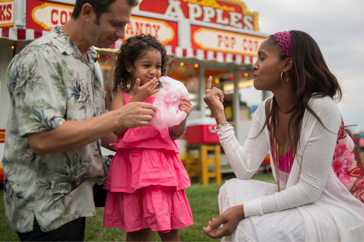 A picture of a family having fun at a carnival. 