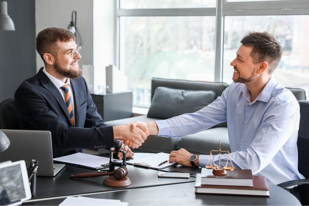 A picture of a man shaking hands with his attorney.