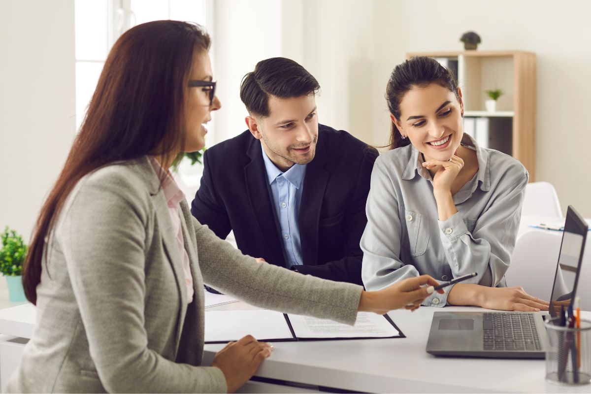 A picture of a real estate agent with her clients.