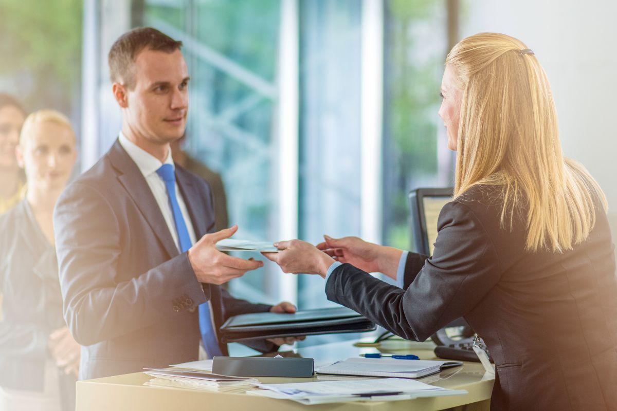 A picture of a Bank Teller giving money to a customer.