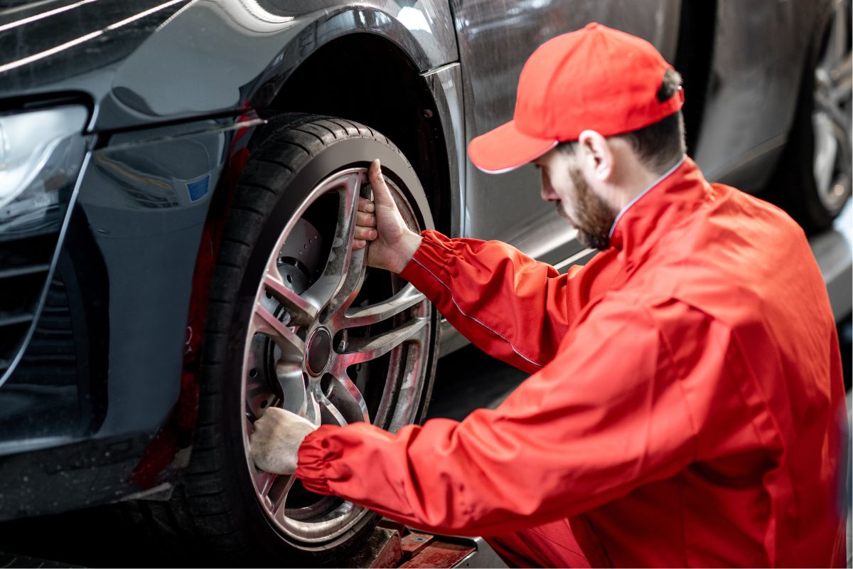 A picture of a mechanic checking tires.