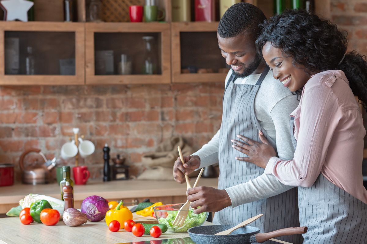 A picture of a couple preparing vegetables as a meal.