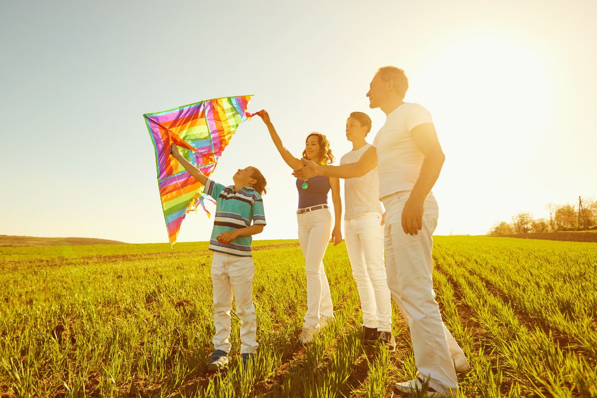 A picture of a family flying a kite.