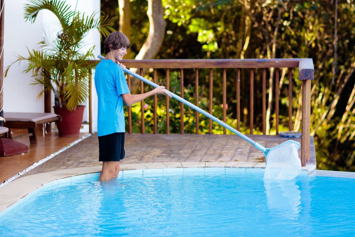 A picture of a boy cleaning a pool.