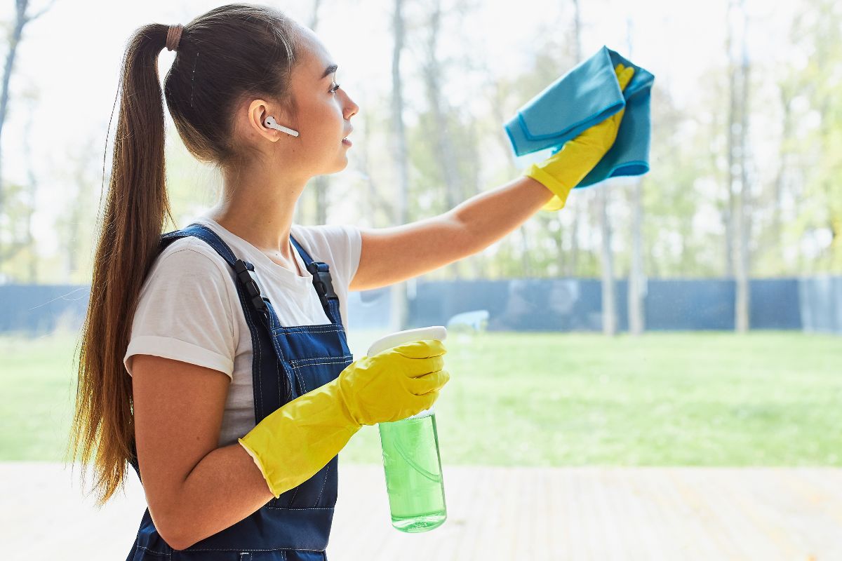 A picture of a lady cleaning a window.
