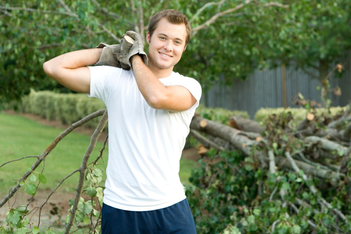 A picture of a man cleaning a yard.