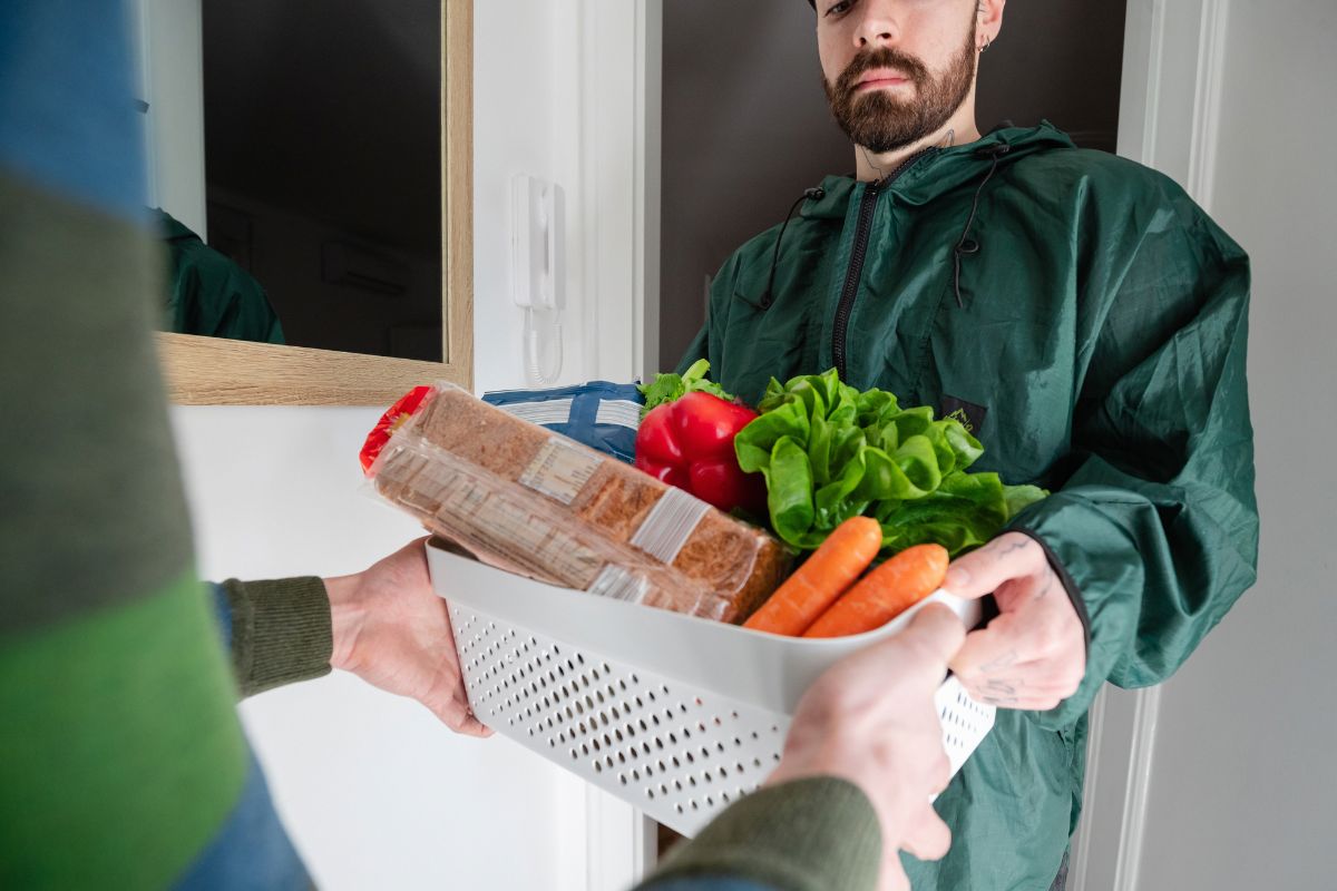 A picture of someone giving his customer groceries.