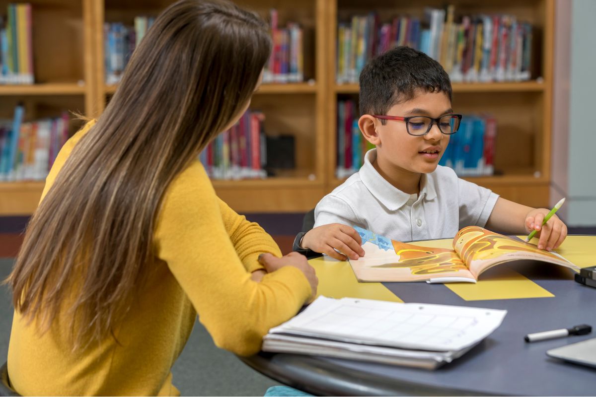 A picture of a lady teaching a kid.