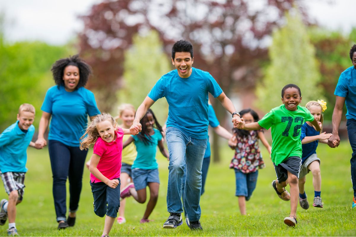 A picture of a man running with kids. 