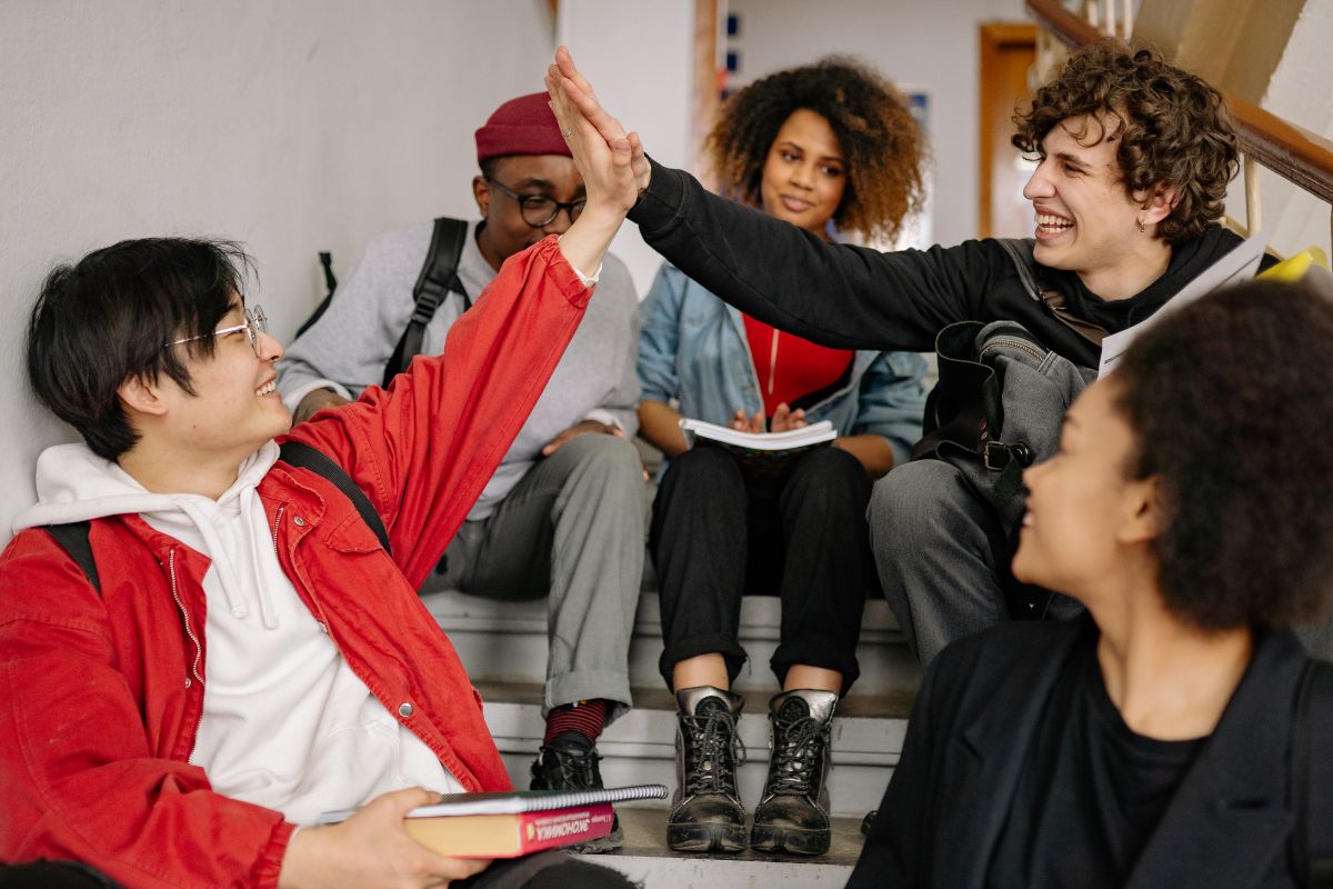 A picture of a teenagers giving each other high fives.