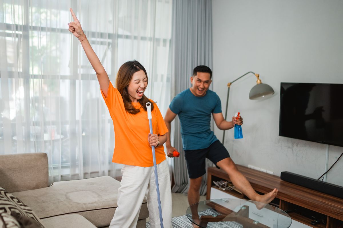 A picture of a couple having fun cleaning their house. 