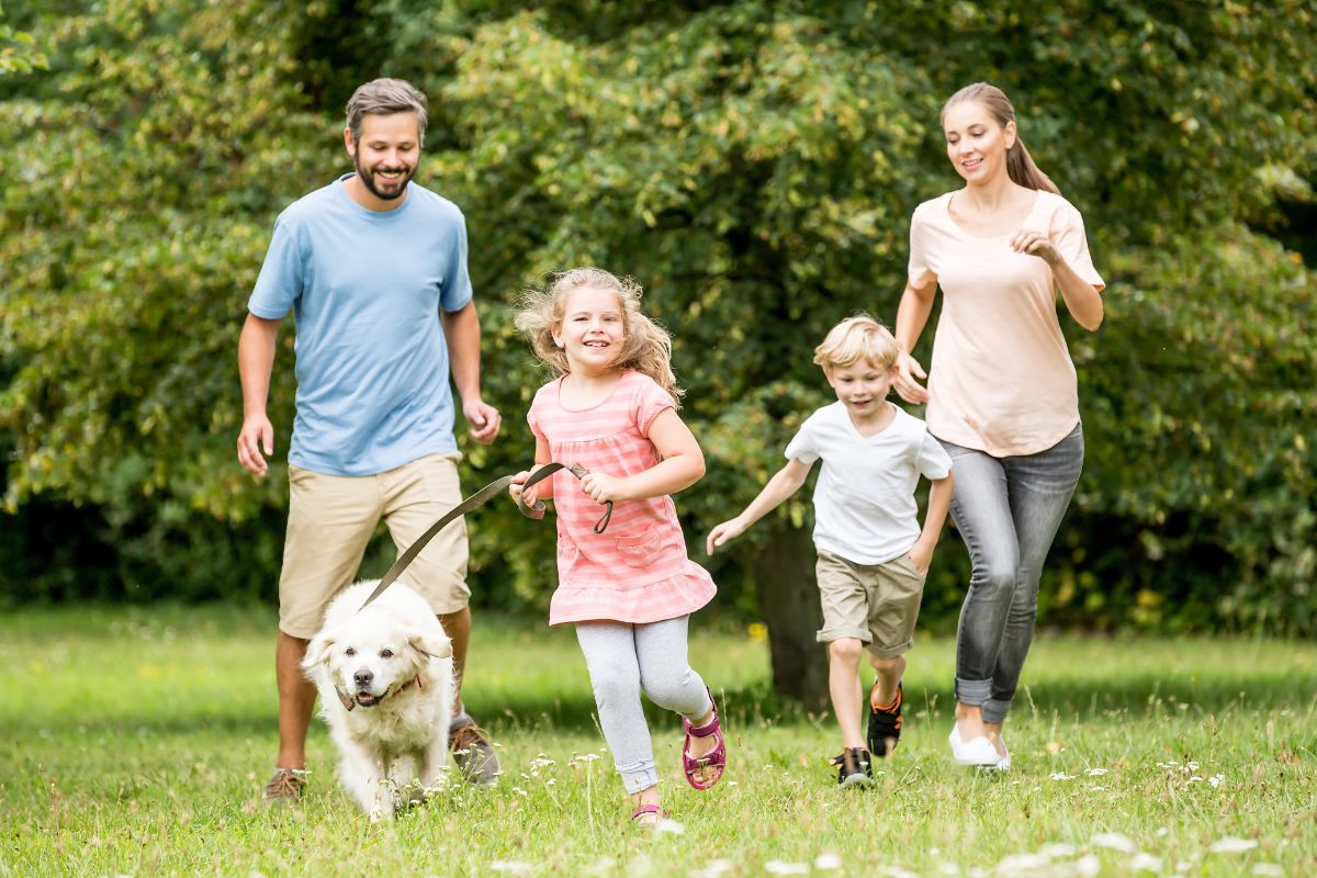 A picture of a family having fun running outside.
