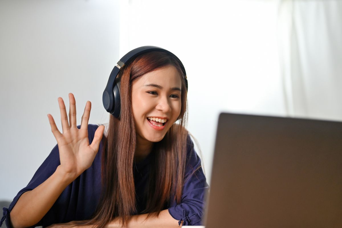 A picture of a lady tutoring someone online.