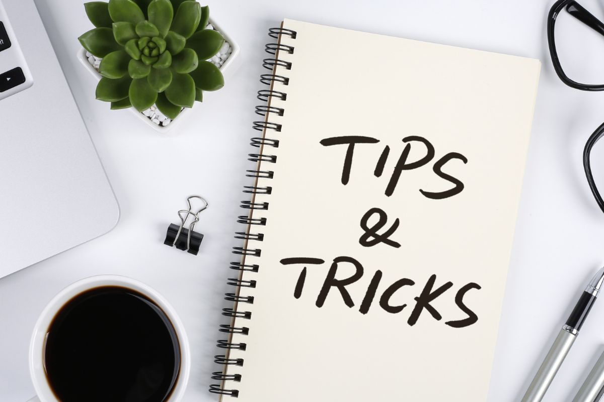 The picture is about a laptop and a notebook with tips and tricks notes.