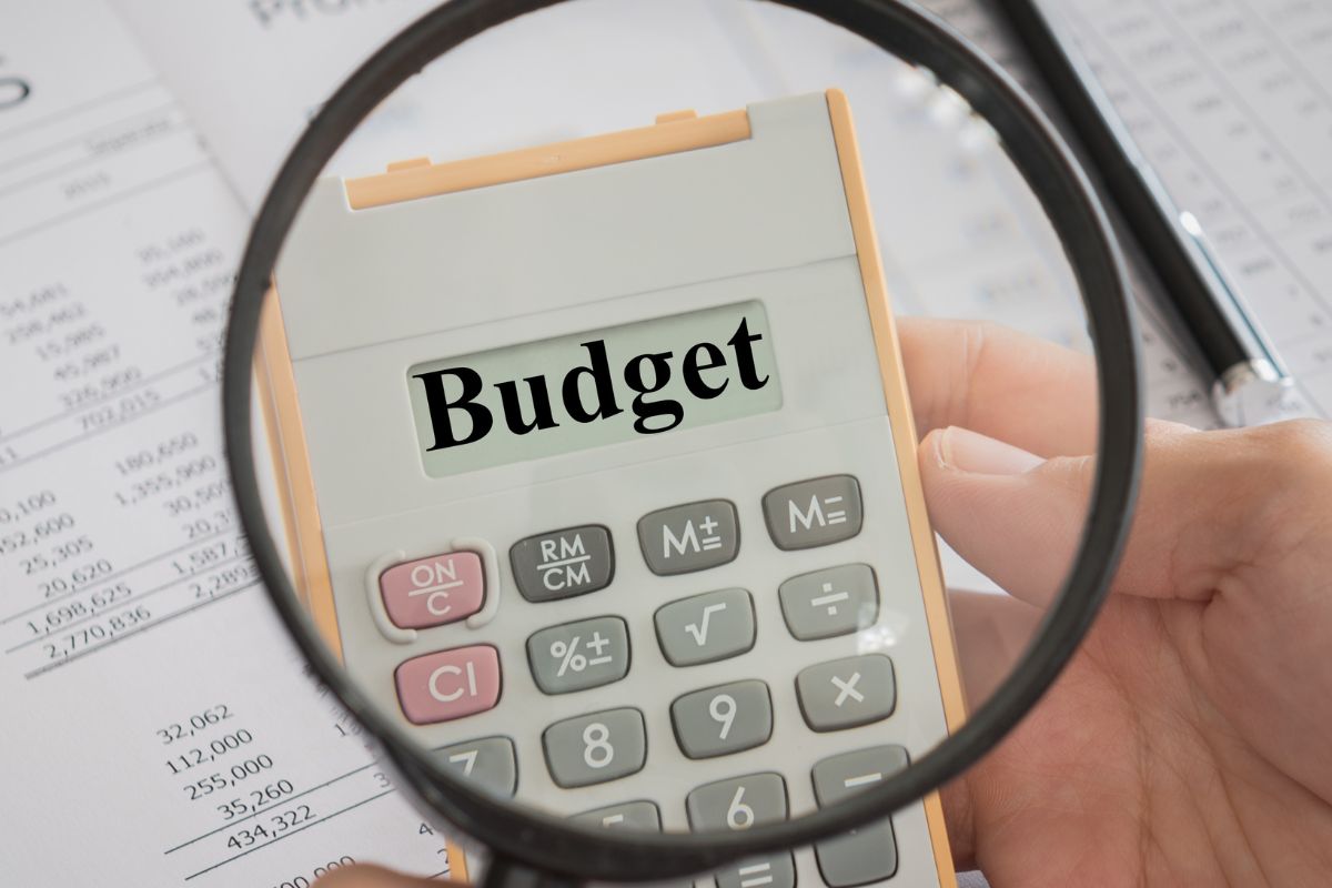 The photo shows a man's hand making a budget that works.