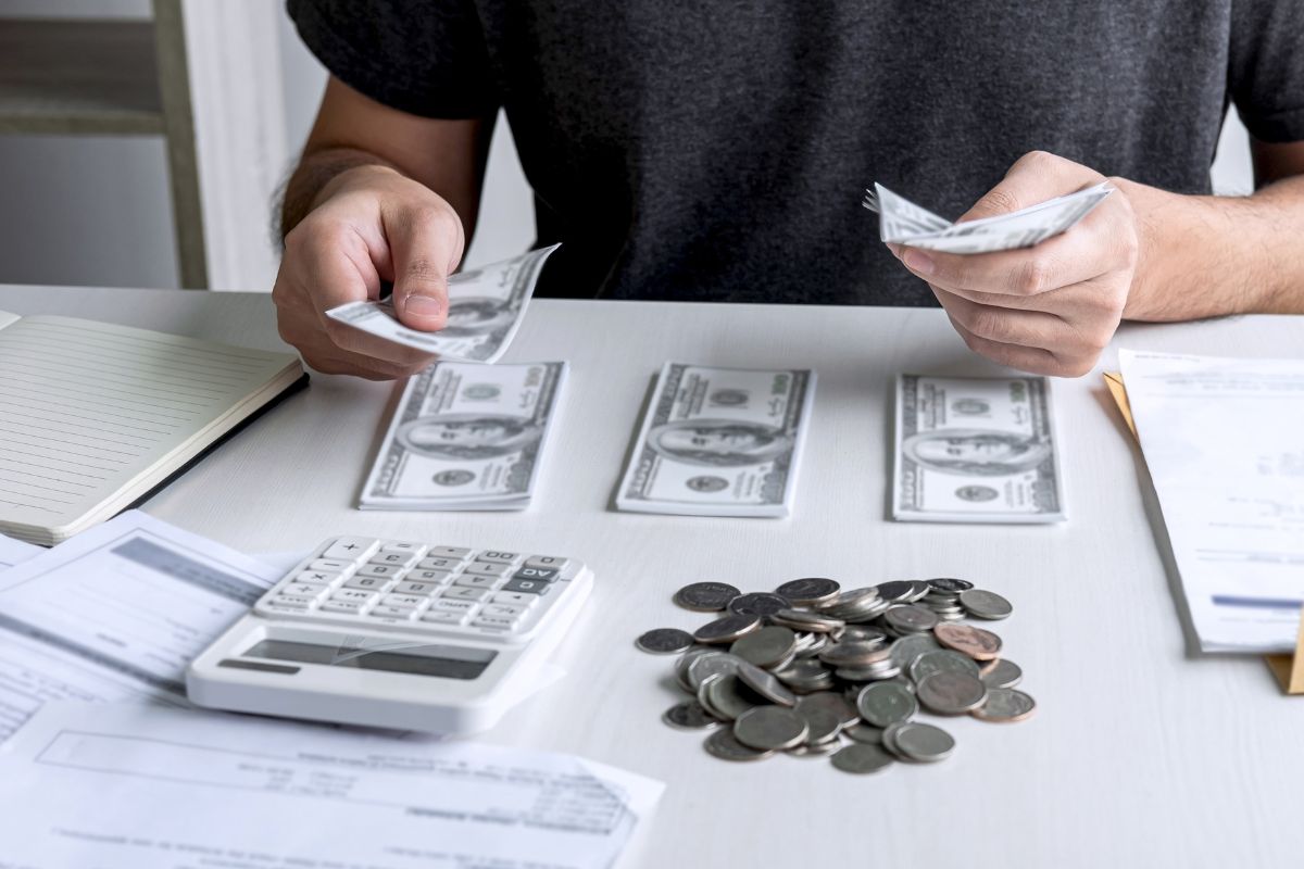 The photo shows a man budgeting his money.