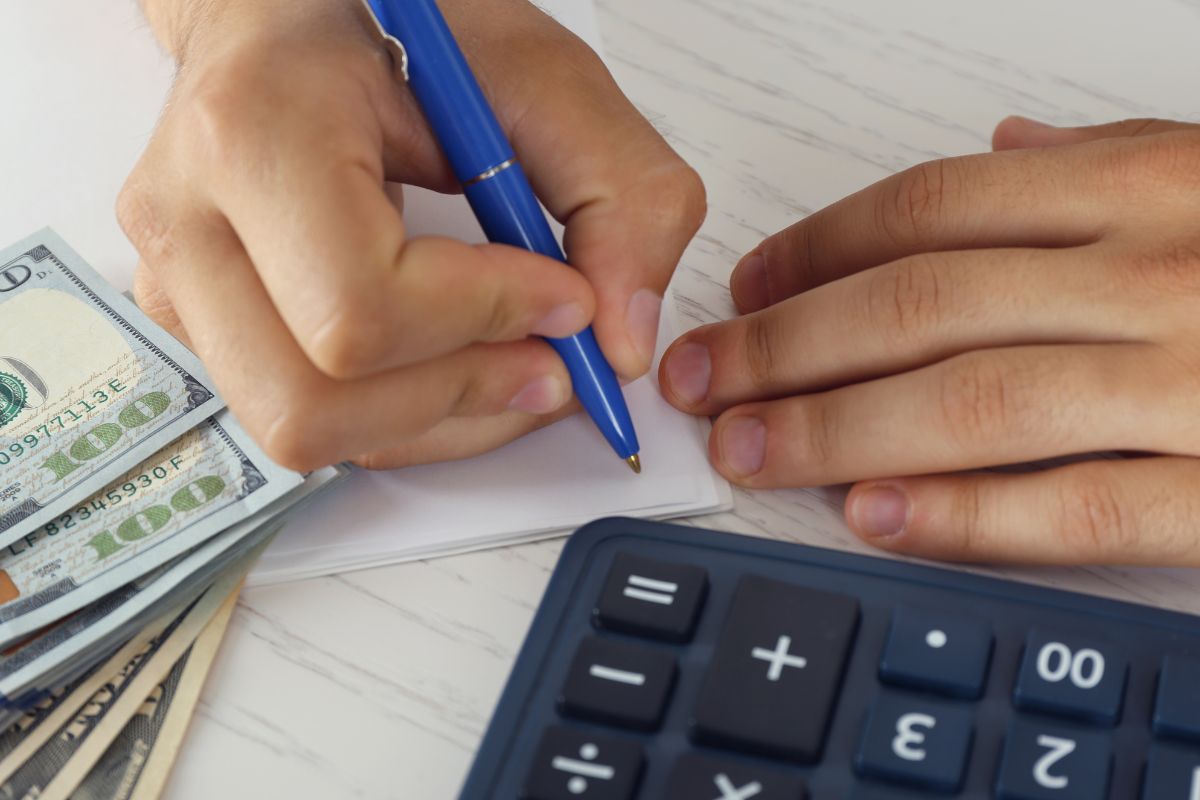 The picture is about a man's hand creating budgets.