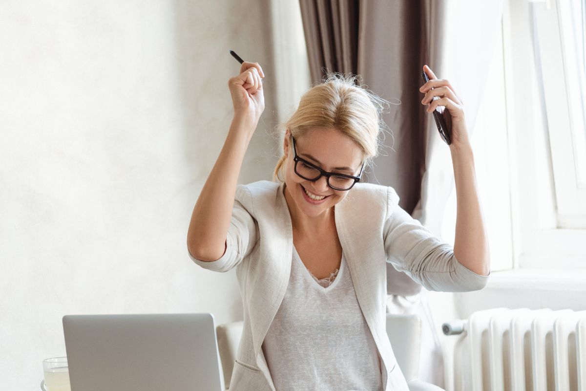 The photo shows a happy lady cheering after the success.