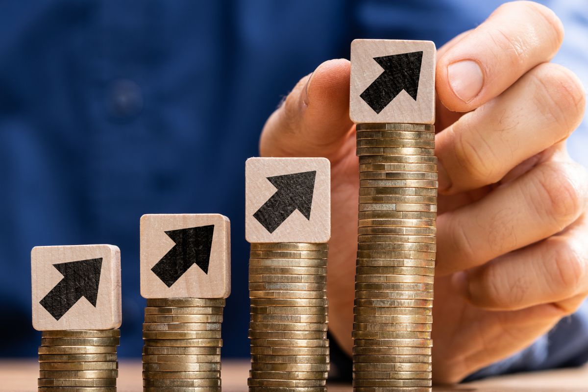 The picture shows a man's hand increasing income through side hustles.