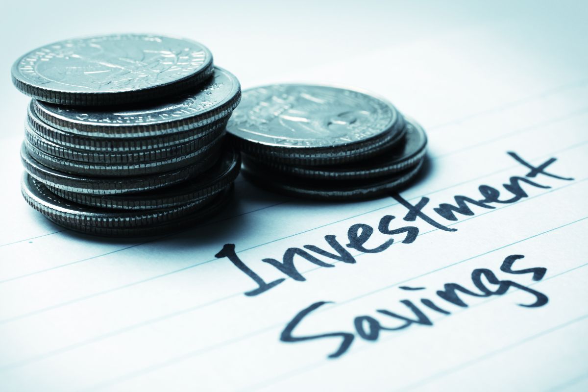 The image is about coins and investment, and savings wording on paper.