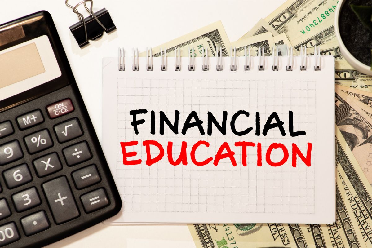 The photo shows dollar bills and a notebook with financial education wording.
