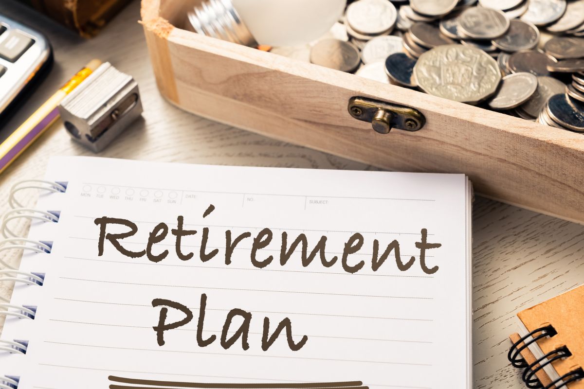 The picture shows coins and a notebook with retirement plan wording.