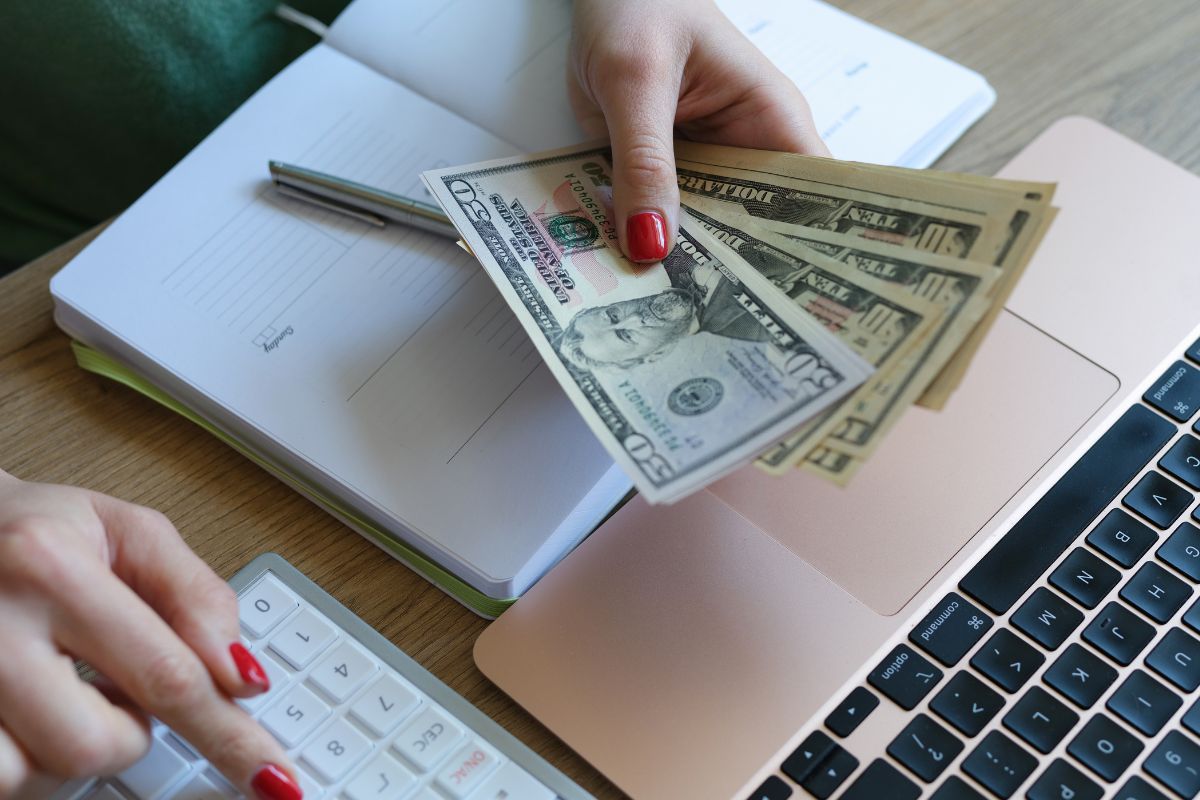 The image shows a woman's hand doing budgeting techniques.