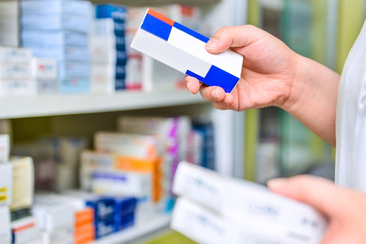 The photo is about a woman's hand buying name-brand medicines.