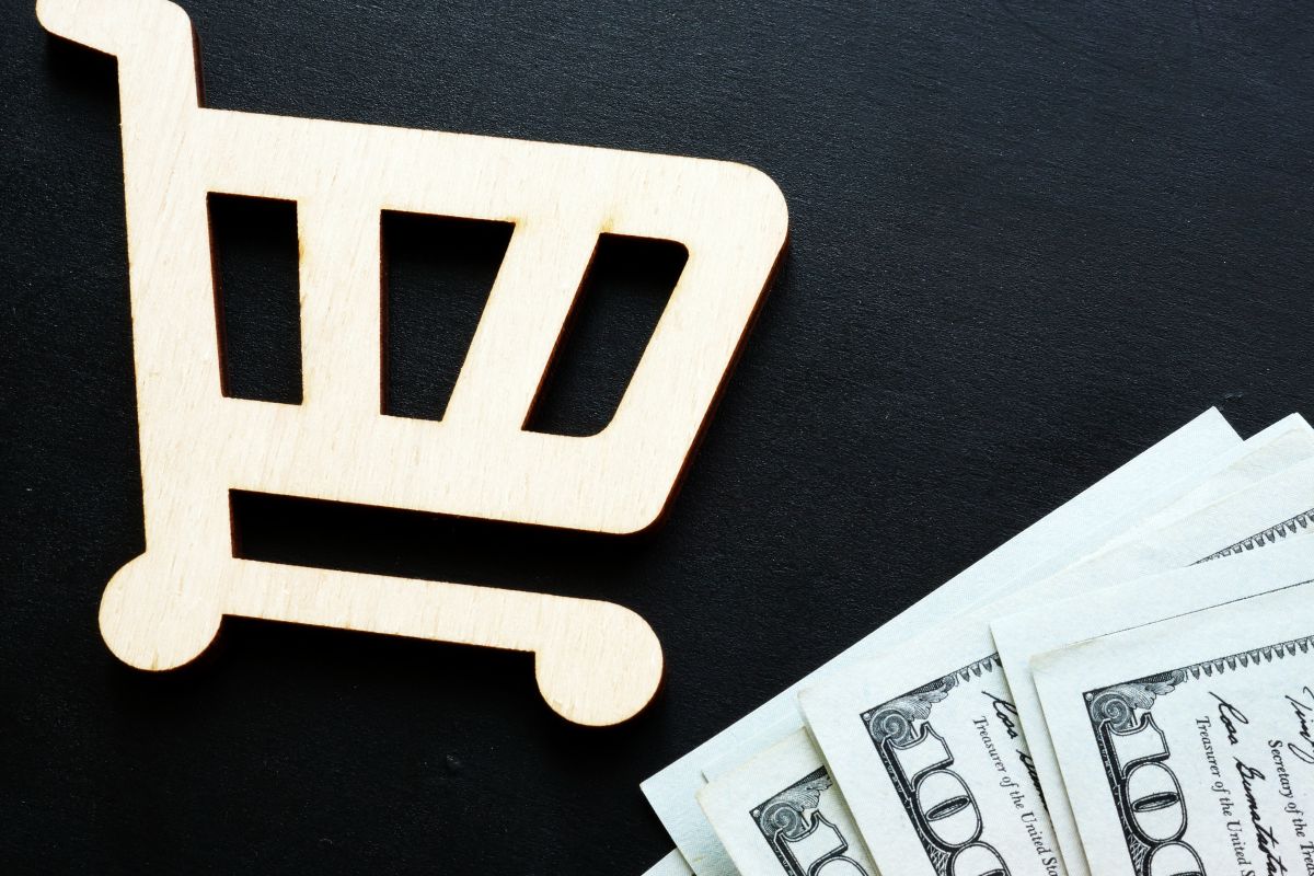 The image shows dollar bills and a cart for a weekly grocery budget.