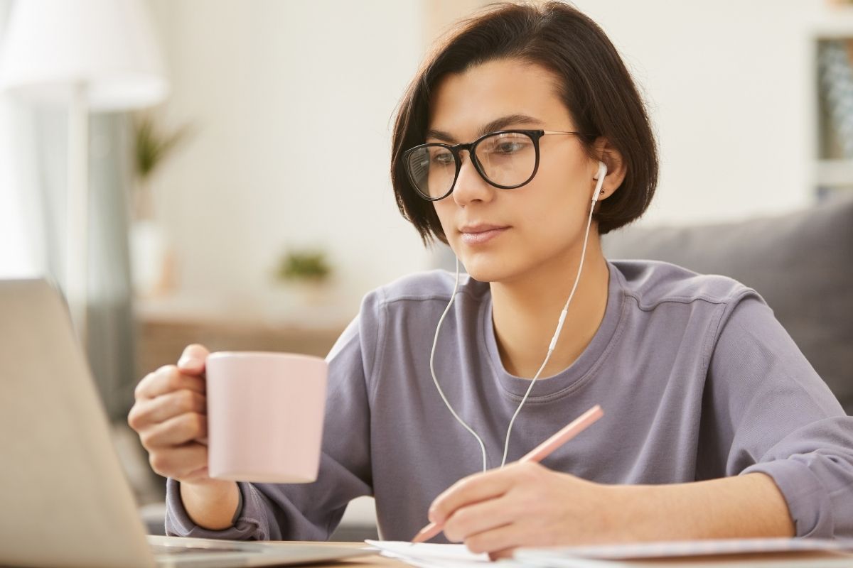 The image tells about a lady working on her laptop as a transcriptionist.