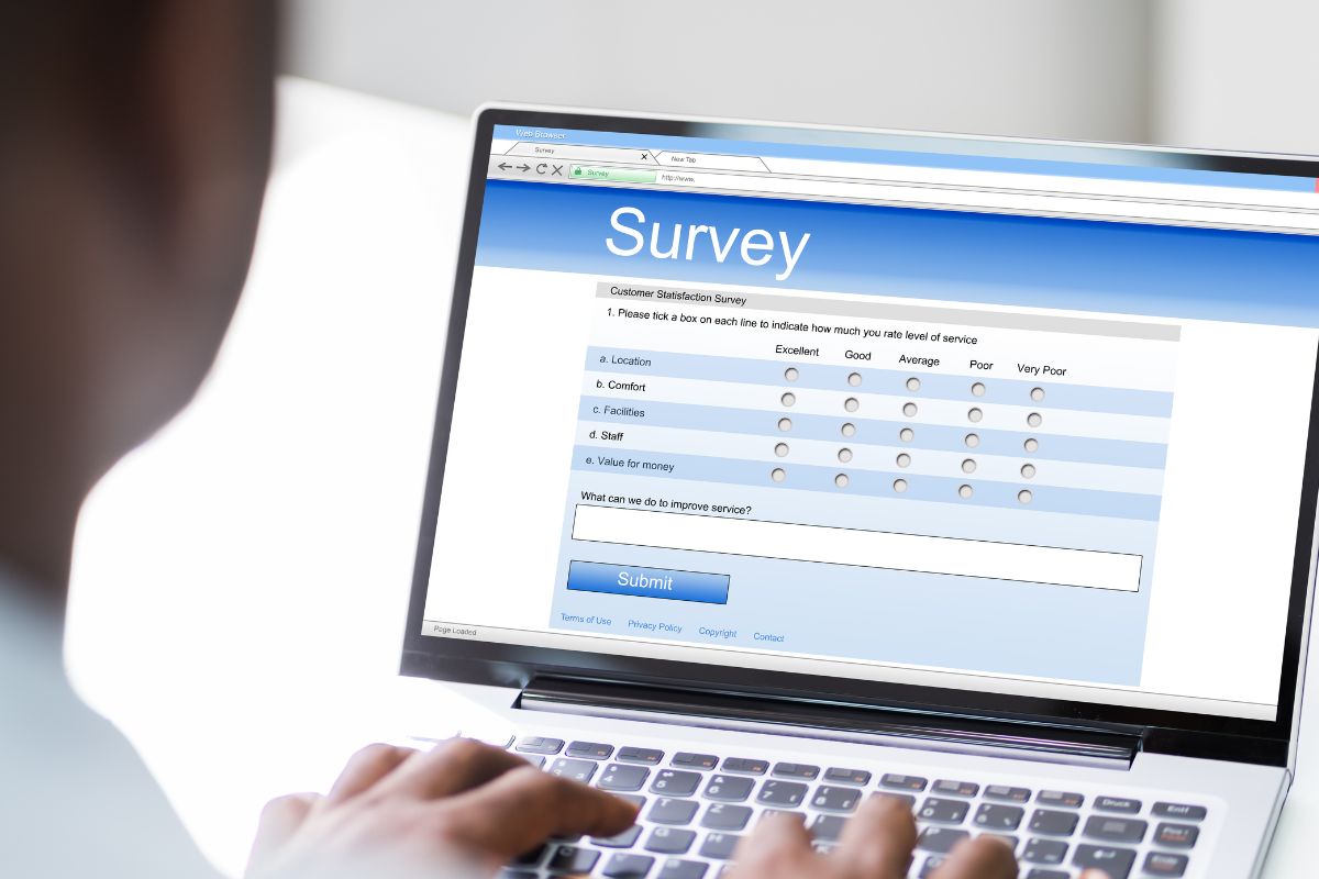 The image shows a man using a laptop as a survey taker.
