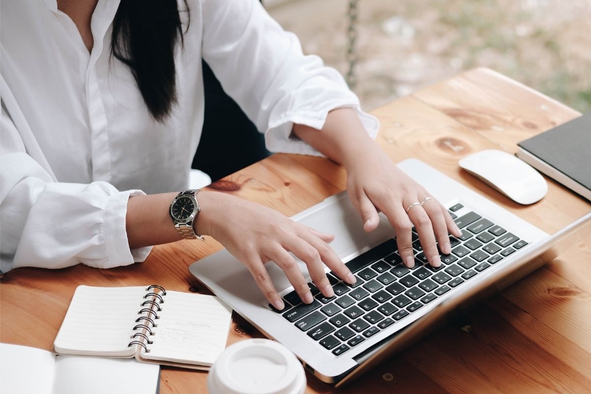 The image of a woman working on her laptop as a medical coder.