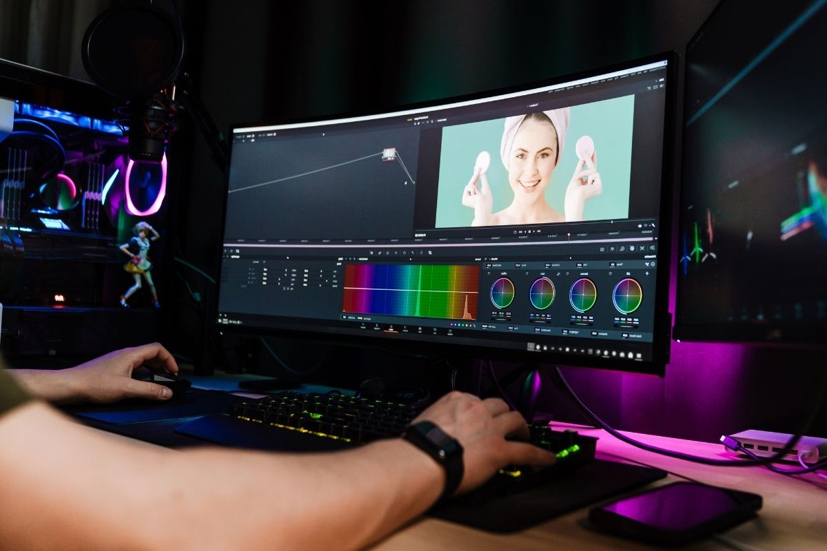 The image shows a man's hand working on his computer as a freelance video editor.